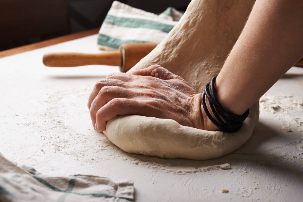 man kneeding bread