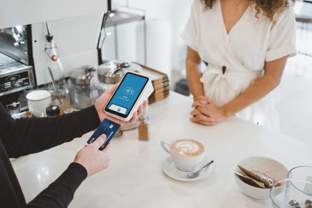 Woman paying for a cup of coffee in a cafe