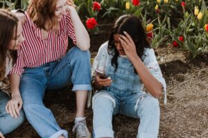 girls smiling and talking in a field